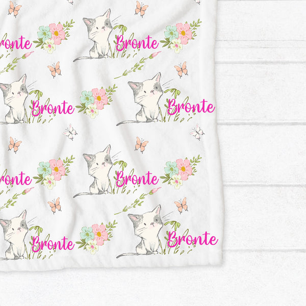 Personalised fleece minky blanket with grey and white kittens playing in a field of pink, blue and white flowers chasing pink and white butterflies