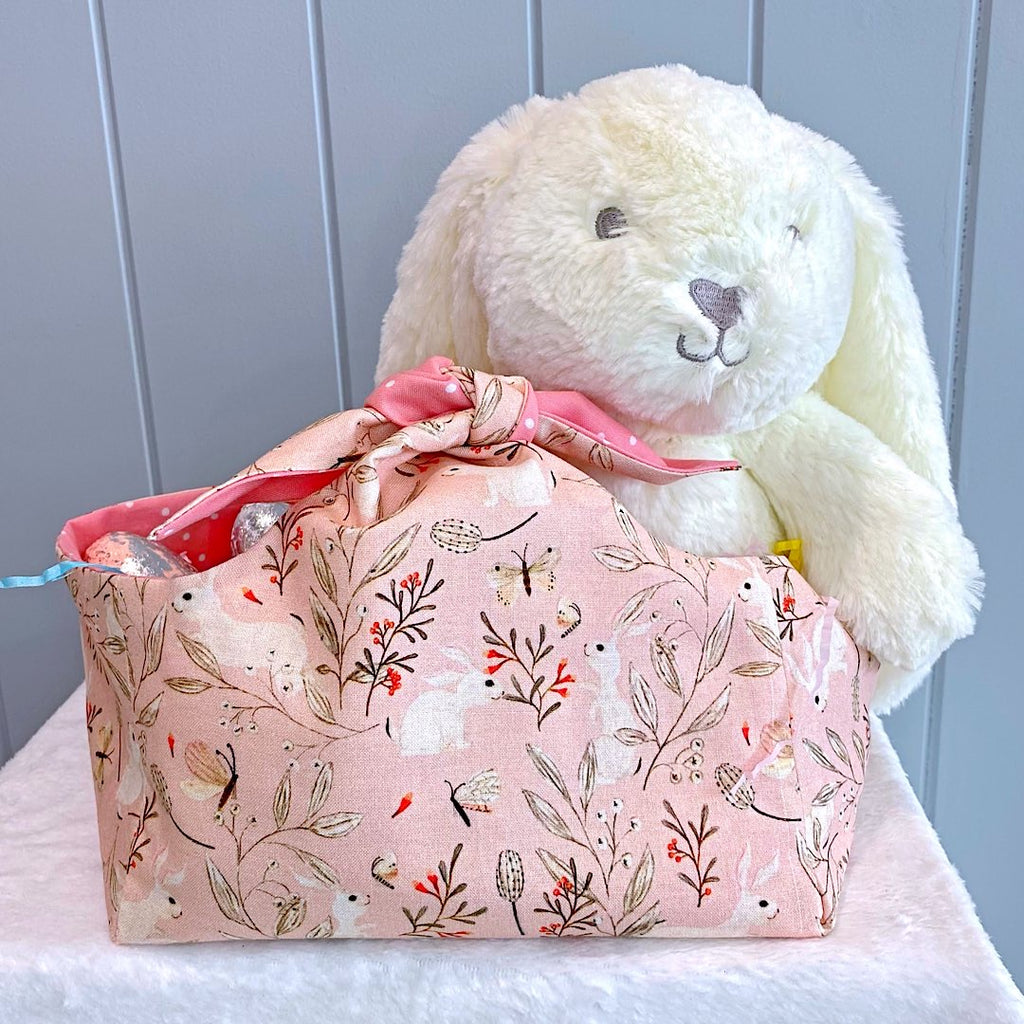 Handmade personalised easter basket bag with outer layer made out of white bunnies on a apricot background fabric and inner lining in a apricot and white spot fabric.