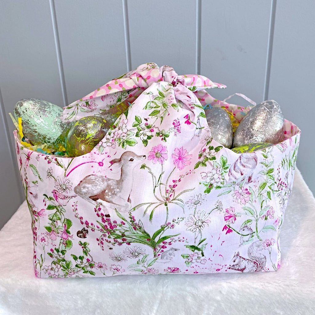Handmade personalised easter basket bag with outer layer made out of woodland creatures on a white background fabric and inner lining in a pink white and green spot fabric.