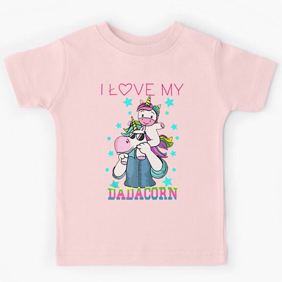 Light pink short sleeved kids tshirt with a muscly white father unicorn wearing a denim button down shirt with a baby unicorn on his shoulders with the words I love my dadacorn underneath