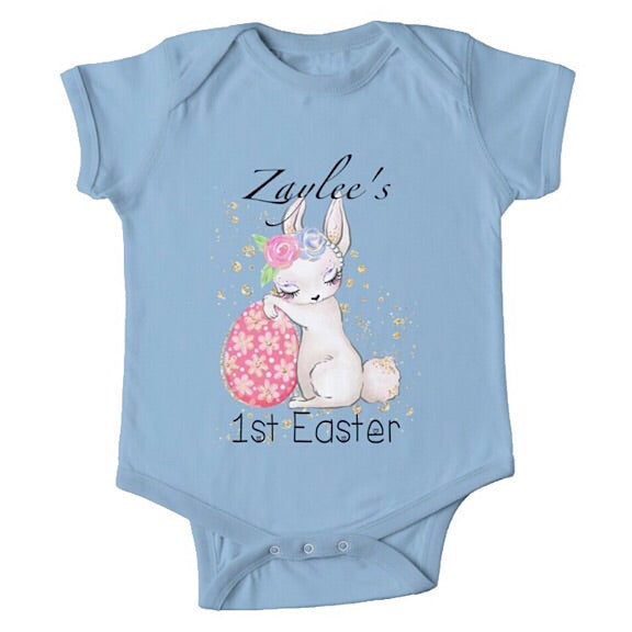 Short sleeved light blue baby onesie for a first easter with a sleepy bunny resting against an Easter egg  personalised with a name