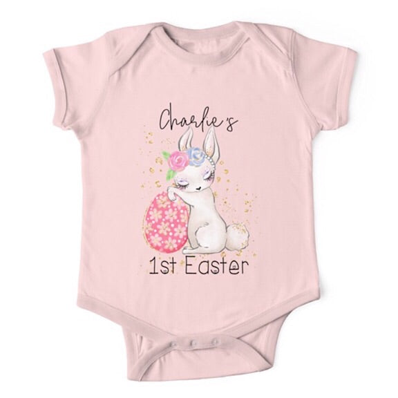 Short sleeved light pink baby onesie for a first easter with a sleepy bunny resting against an Easter egg  personalised with a name