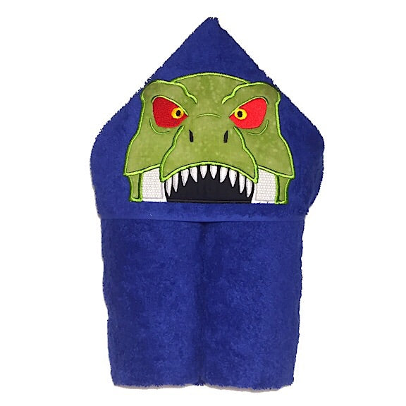 Hooded bath beach swim towel in blue with blue hood. Hood has the face of an angry green tree dinosaur showing lots of wheat teeth and red eyes  appliquéd in the centre. Ready to be personalised with a name.
