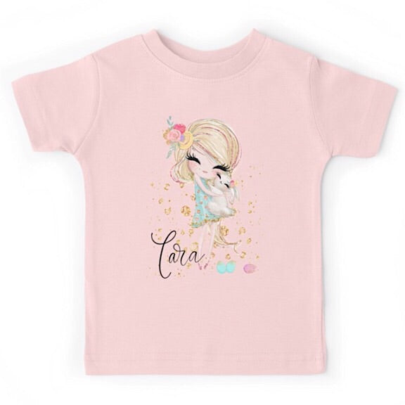 Light pink short sleeved tshirt with a blonde haired girl cuddling a white bunny, personalised with a name