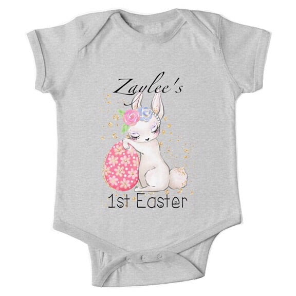 Short sleeved light grey baby onesie for a first easter with a sleepy bunny resting against an Easter egg  personalised with a name