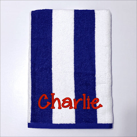 Beach towel in navy blue and white stripe, personalised with a name.
