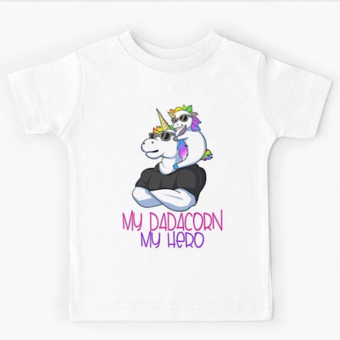 White short sleeved kids tshirt with a muscly white father unicorn wearing a black tshirt with a baby unicorn on his shoulders with the words my dadacorn my hero underneath
