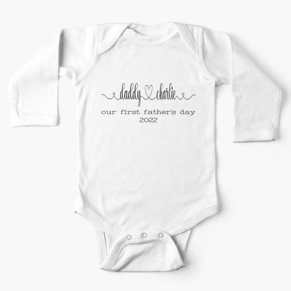 Personalised white long sleeved baby onesie for first fathers day with the names of both father and child combined with a heart