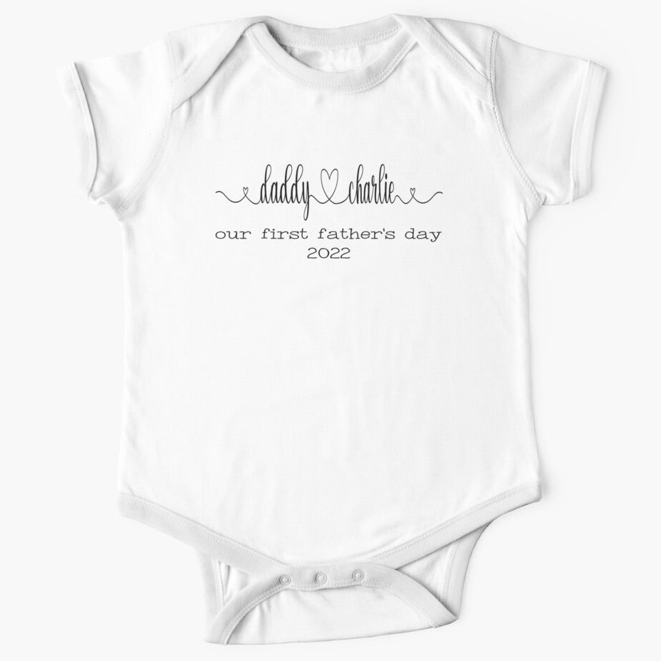 Personalised white short sleeved baby onesie for first fathers day with the names of both father and child combined with a heart