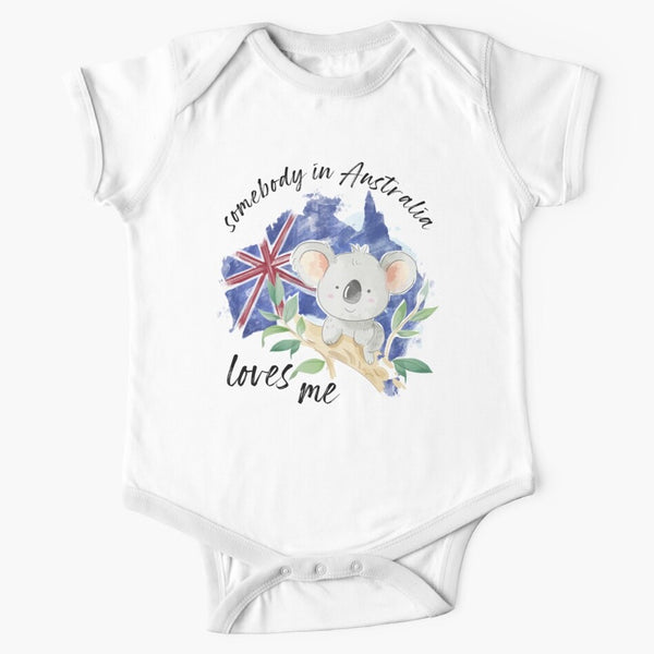 White short sleeved onesie with somebody in Australia loves you written in cursive text around the picture of a grey koala sitting on the branch of a gumtree on the background of the australian flag