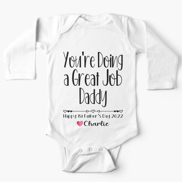 Personalised white long sleeved baby onesie for first fathers day with the words you're doing a great job daddy